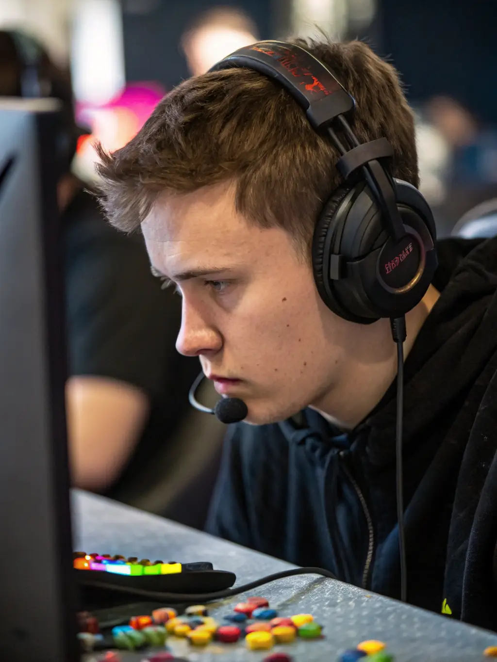 A young eSports player intensely focused on their computer screen during a training session at GE's facility, showcasing dedication and concentration.